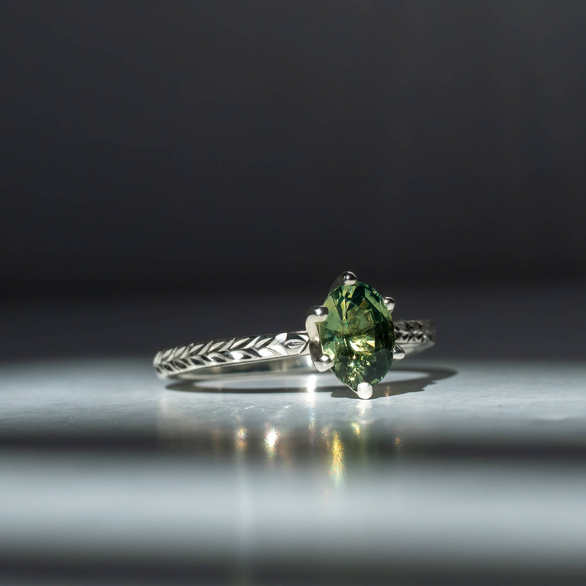 Elowyn green oval sapphire engagement ring with hand-engraved laurel band