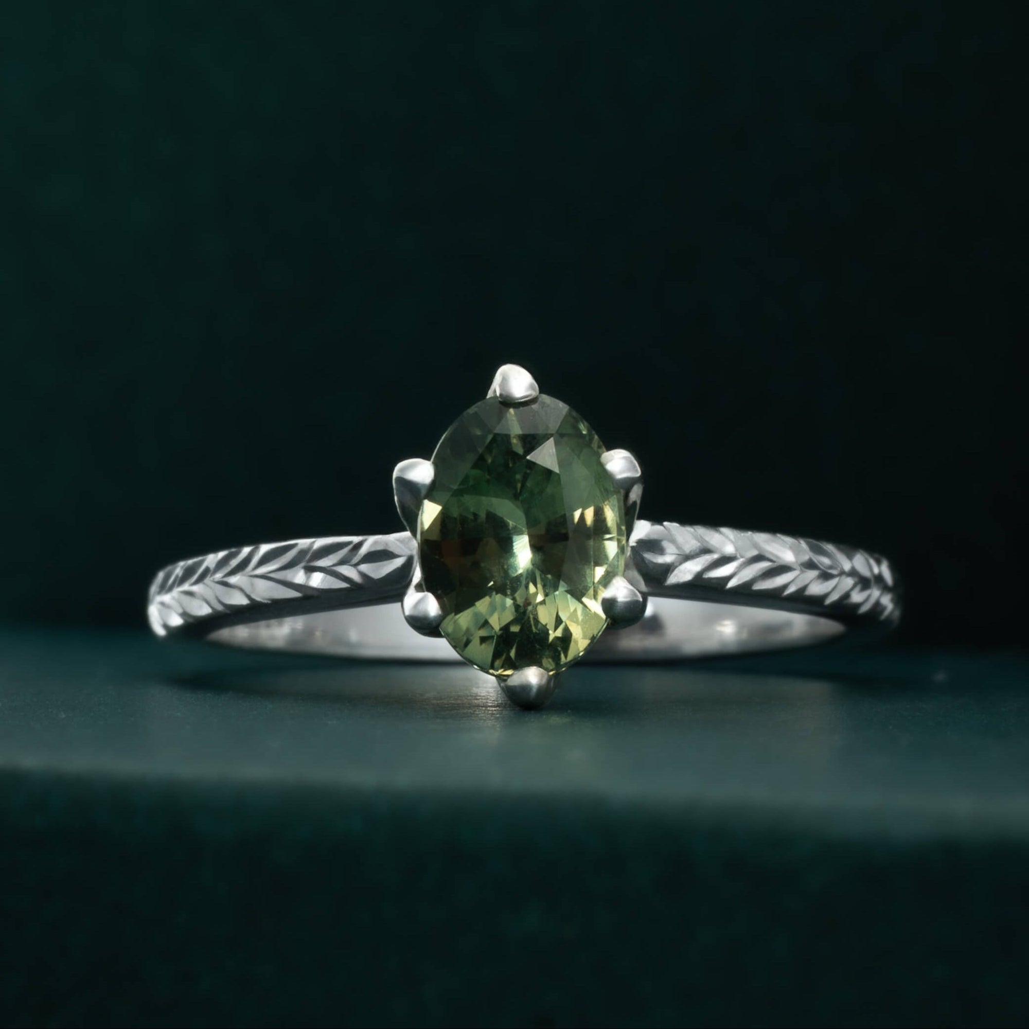 Nature-inspired oval green sapphire ring with tulip cathedral and leaf engraving