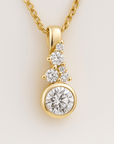 Gold necklace with a diamond pendant on a light beige background