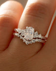 Close-up of a hand wearing a diamond ring with a pear-shaped center stone.