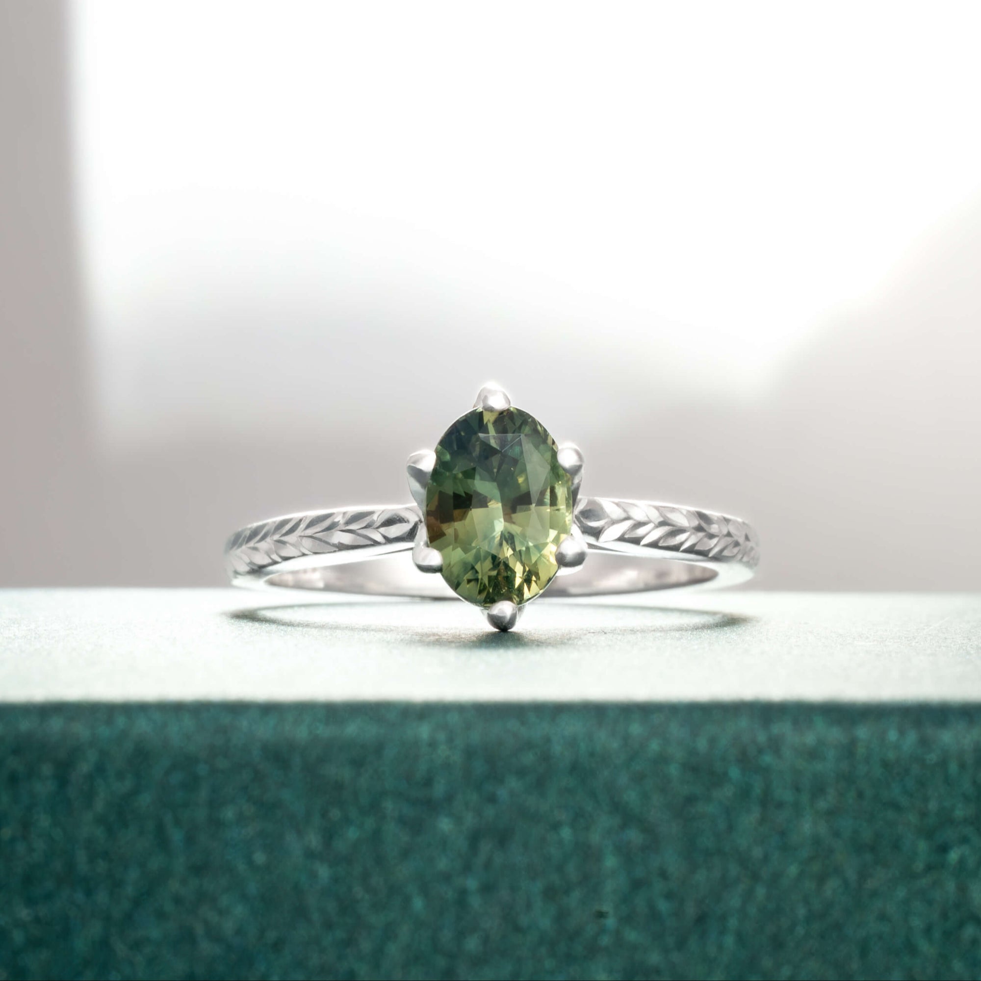 Ring with a green gemstone on a textured surface