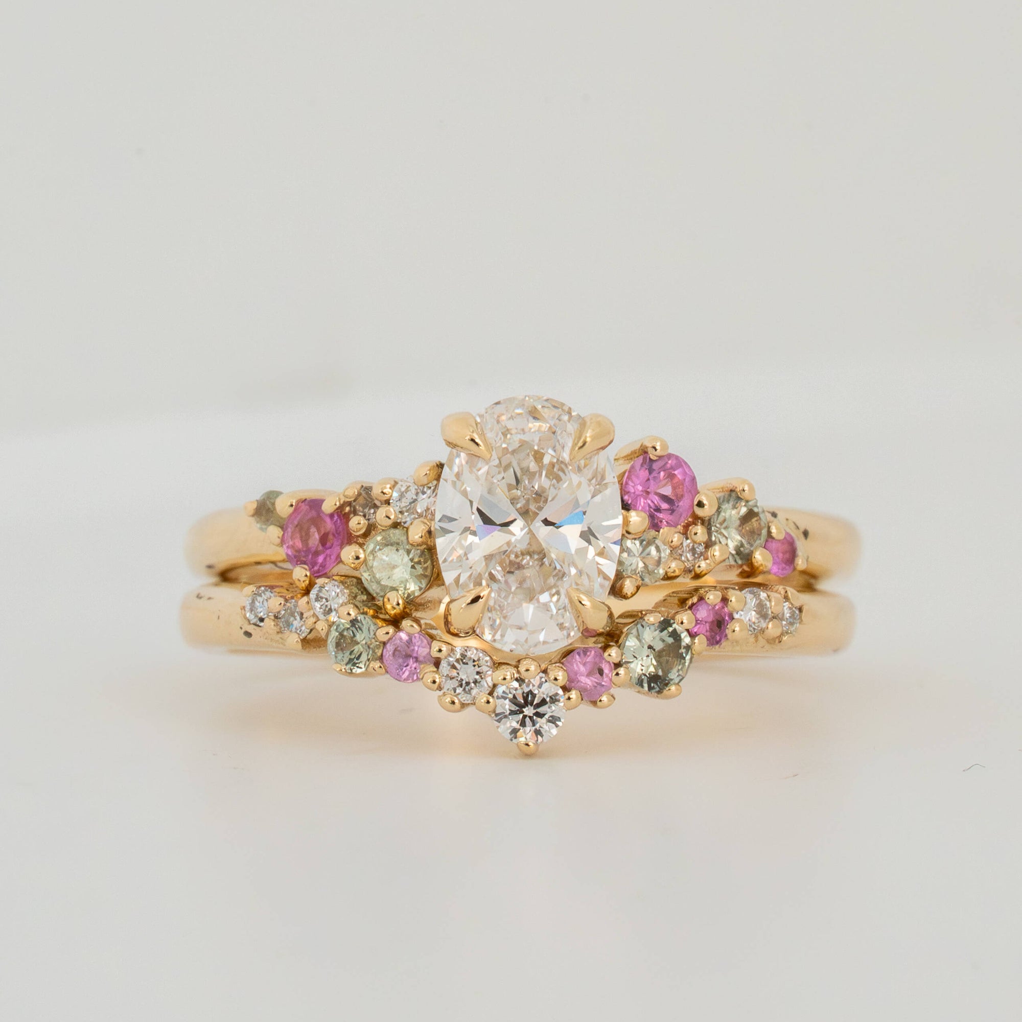 Gold ring with gemstones on a light gray background